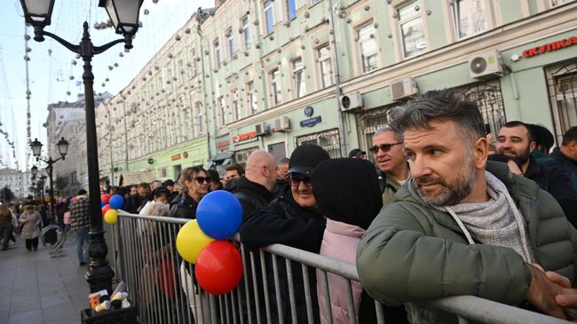 Граждане Молдавии стоят в очереди на избирательный участок на выборах президента и конституционном референдуме по вопросу евроинтеграции перед посольством Молдавии в центре Москвы