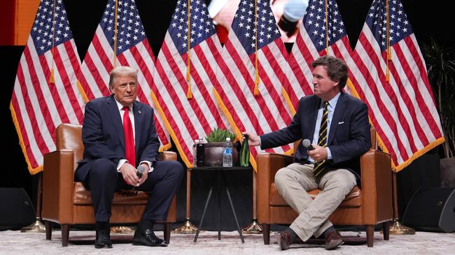 Американский президент Дональд Трамп беседует с Такером Карлсоном
