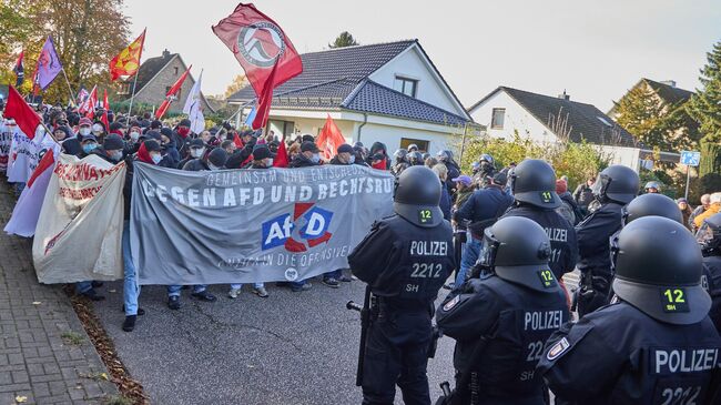 Сотрудники полиции и участники акции протеста против конференции партии Альтернатива для Германии (АдГ) в городе Хенштедт-Ульцбург, Германия