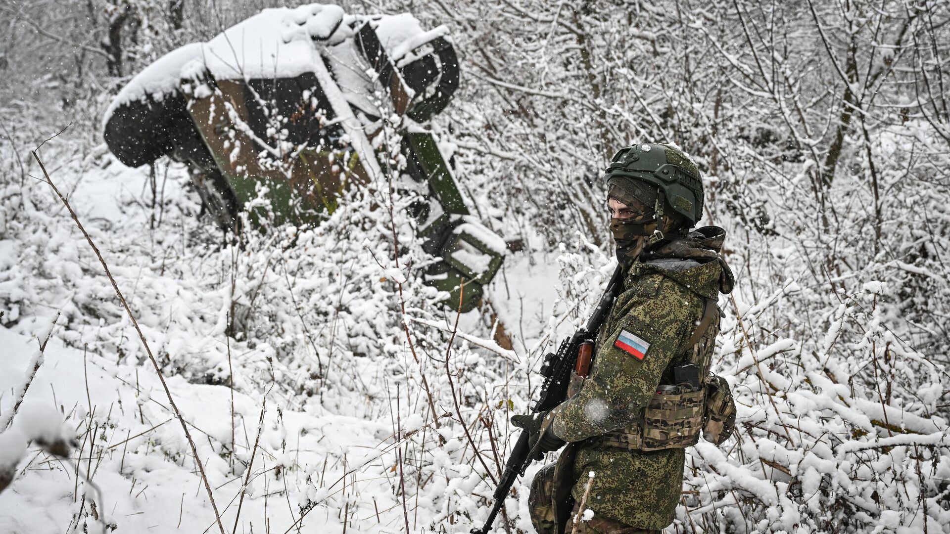 Военнослужащий батальонной тактической группы под командованием Каштана спецназа Ахмат возле подбитого бронеавтомобиля иностранного производства в Курской области - РИА Новости, 1920, 17.11.2024