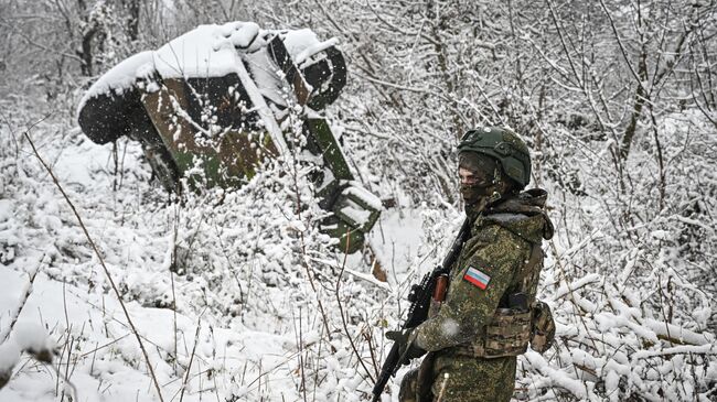 Российский военнослужащий возле подбитого бронеавтомобиля иностранного производства в Курской области