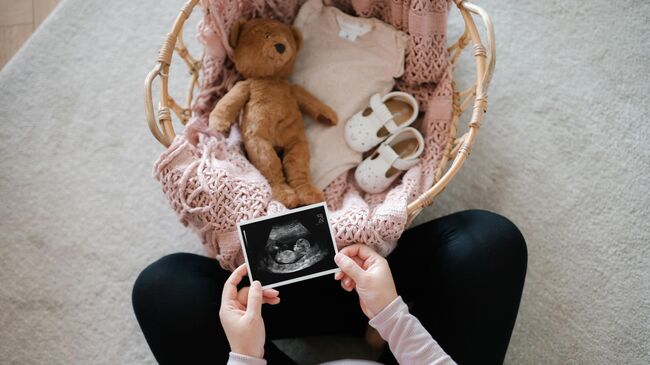 Беременная женщина рассматривает снимок УЗИ