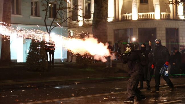 Протестующие запускают фейрверк в сторону полицейских в Тбилиси