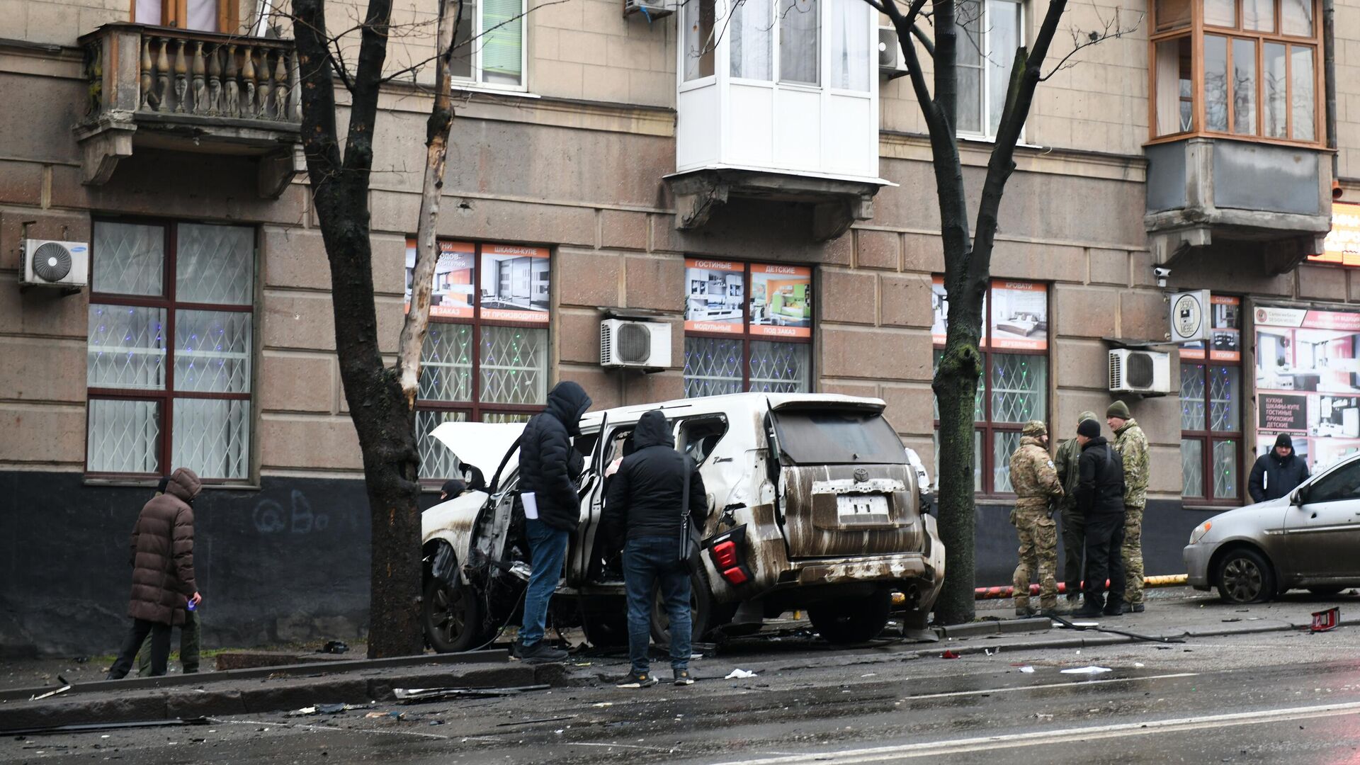 Белый Toyota Land Cruiser Prado, поврежденный взрывом, на улице в центре Донецка - РИА Новости, 1920, 09.12.2024