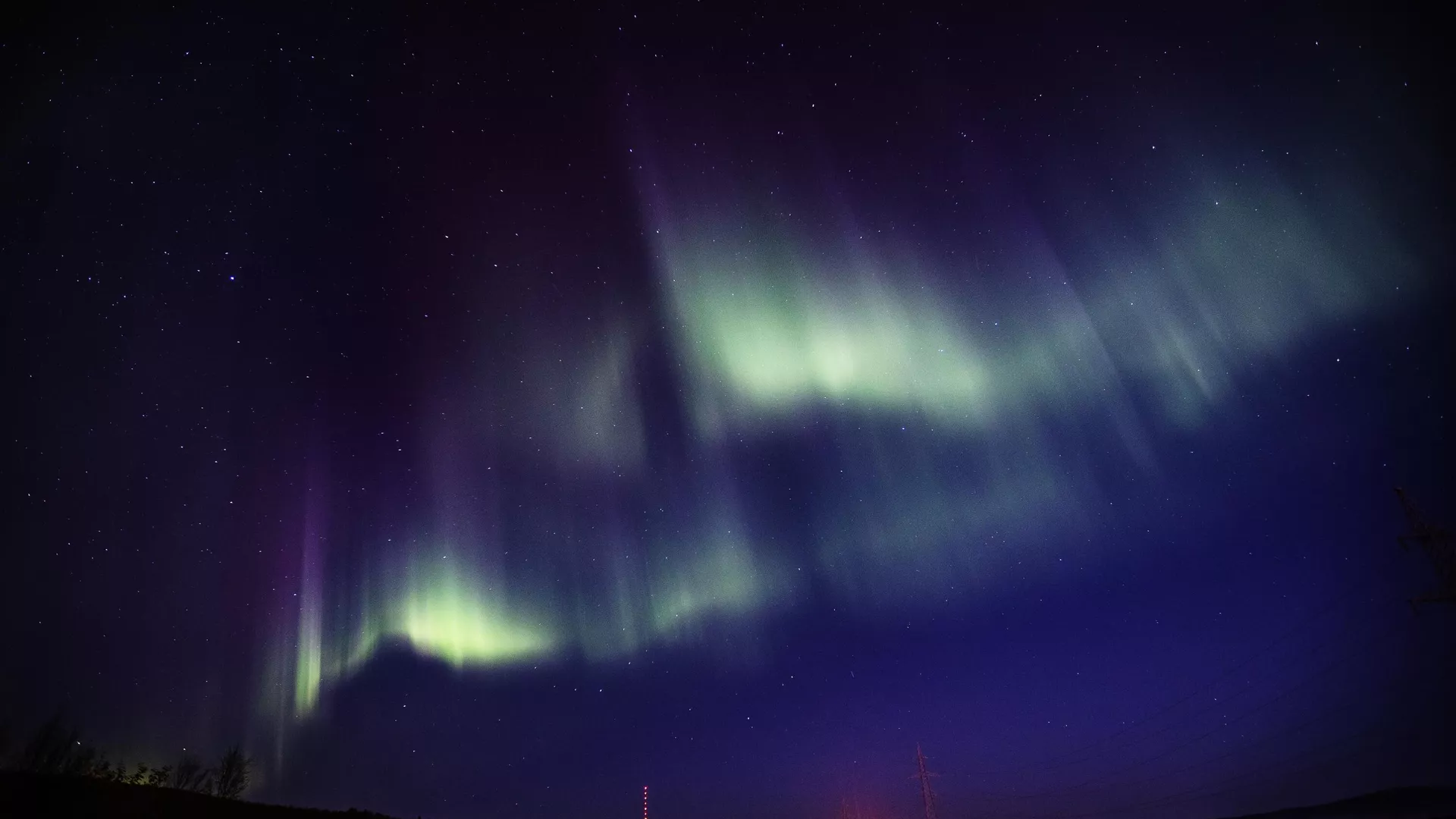Яркое северное сияние над заснеженным ландшафтом