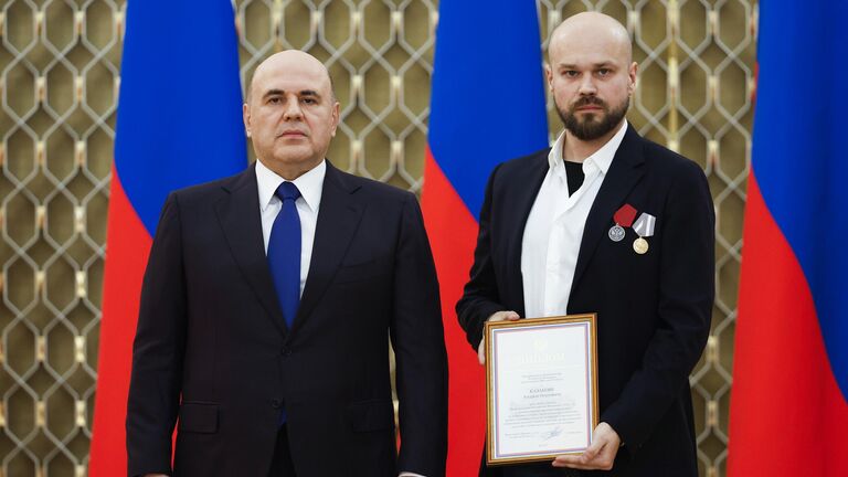 Председатель правительства РФ Михаил Мишустин и корреспондент дипломатической редакции управления международной информации главной дирекции информации федерального государственного унитарного предприятия Международное информационное агентство Россия сегодня Андрей Казаков на церемонии вручения премий правительства в области средств массовой информации за 2024 год