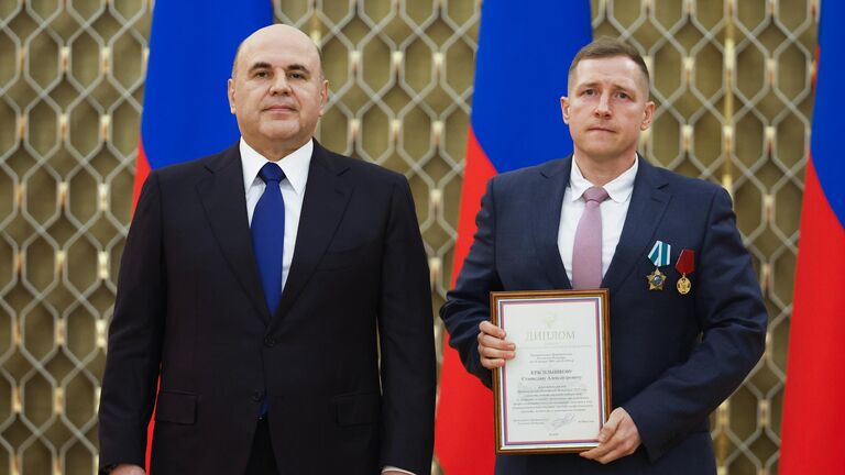 Председатель правительства РФ Михаил Мишустин и специальный фотокорреспондент Международной медиагруппы Россия сегодня Станислав Красильников на церемонии вручения премий правительства в области средств массовой информации за 2024 год