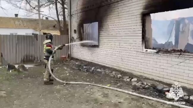 Сотрудник МЧС во время ликвидации пожара в частном доме в селе Брянск в Кизлярском районе Дагестана. Кадр видео