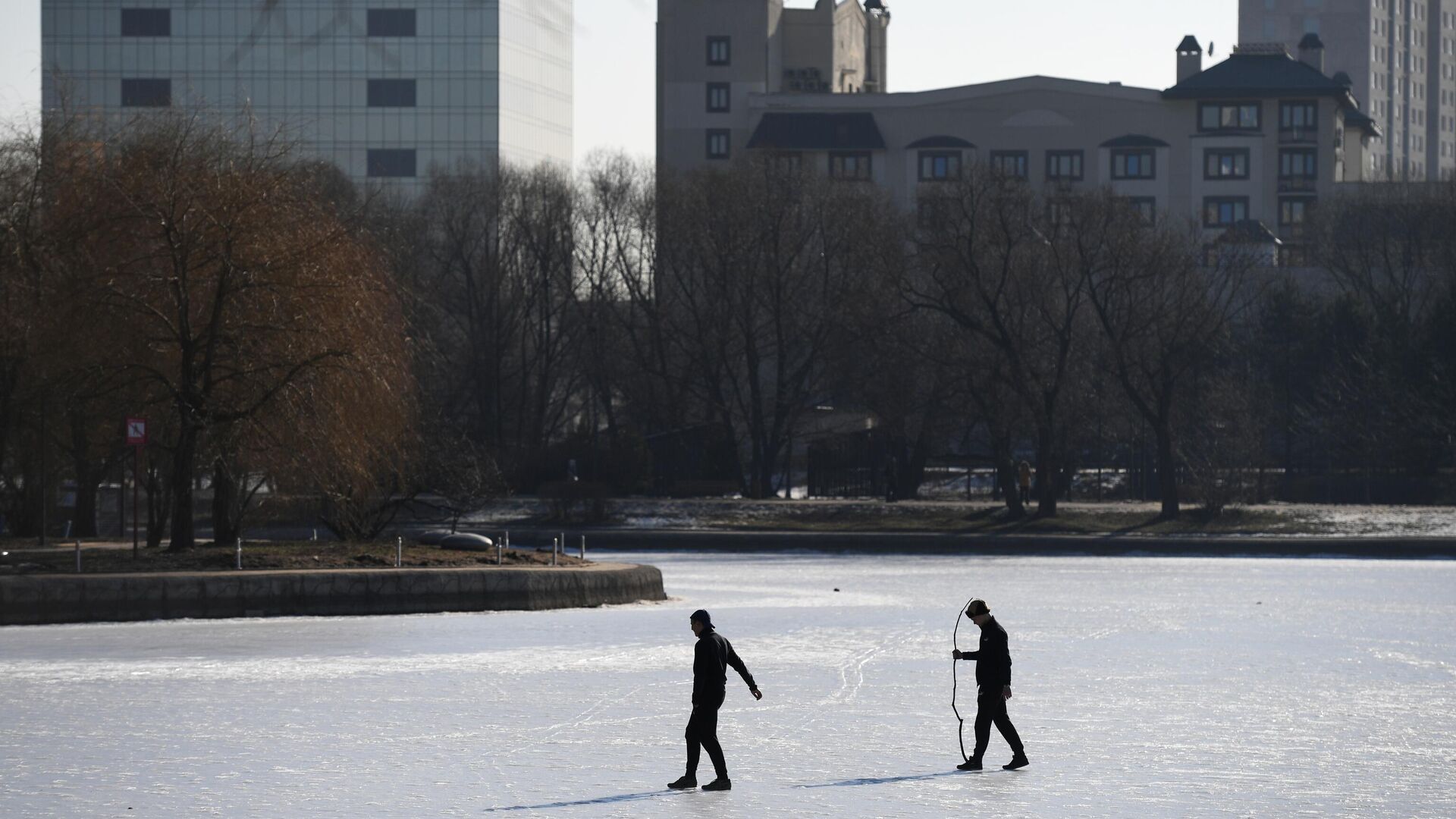 Мужчины ходят по замерзшему пруду в парке Дружбы в Москве Мужчины ходят по замерзшему пруду в парке Дружбы в Москве - РИА Новости, 1920, 24.01.2025