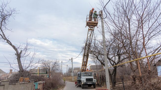 Сотрудники коммунальных служб ремонтируют линию электропередачи 