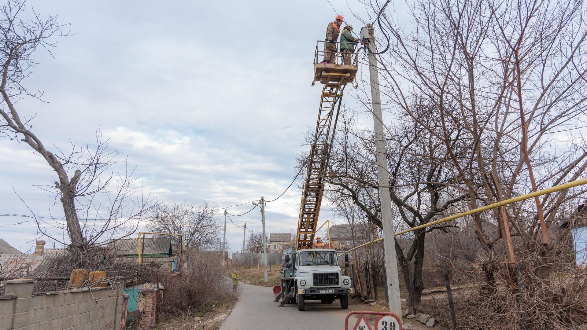 Сотрудники коммунальных служб ремонтируют линию электропередачи  - РИА Новости, 1920, 14.12.2025
