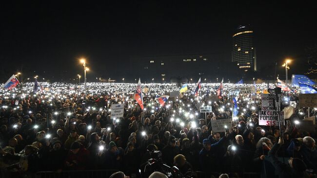 Люди зажигают телефоны во время митинга против политики премьер-министра Роберта Фицо в Братиславе, Словакия