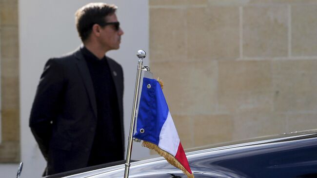 Телохранитель возле автомобиля с флагом Франции