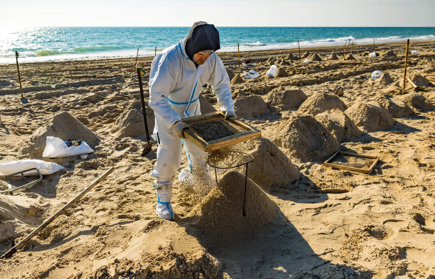 Просеивание песка через сито для выявления мелких фракций мазута