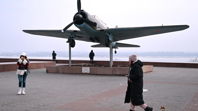 Прохожие у памятника самолету Су-2 в Волгограде