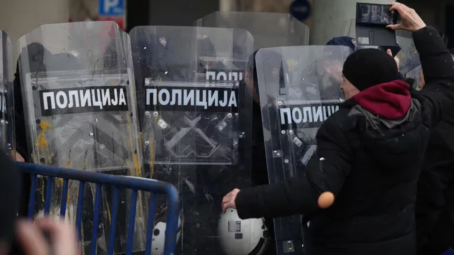 Участники протестной акции забросали кордон полиции яйцами, мукой и краской в знак протеста против избрания мэром Жарко Мичина экс-главы кабинета премьера Милоша Вучевича в Нови-Саде