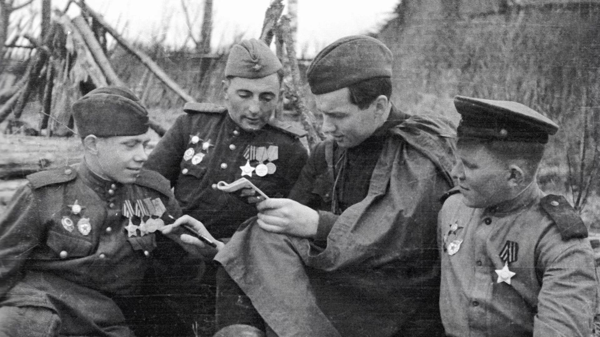 Советский журналист, военный корреспондент Константин Лапин (второй справа) беседует с бойцами фронта в освобожденной деревне Каруза Калининской области   - РИА Новости, 1920, 28.02.2025