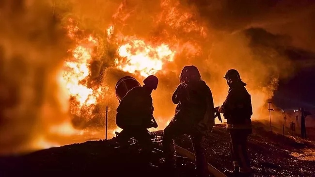 Сотрудники пожарной службы Украины во время тушения пожара на промышленном объекте в Киеве. 27 февраля 2025