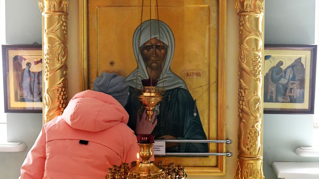© РИА Новости / Илья НаймушинПерейти в медиабанк<br>Верующая молится у иконы Святой Матроны Московской. Архивное фото