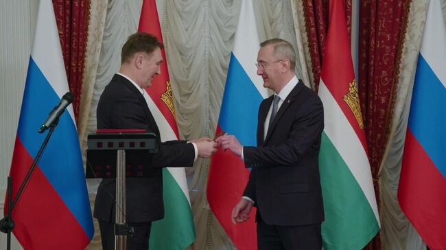 Губернатор Калужской области Владислав Шапша вручает российский паспорт переехавшему из Германии соотечественнику Вадиму Цовбуну. Кадр видео