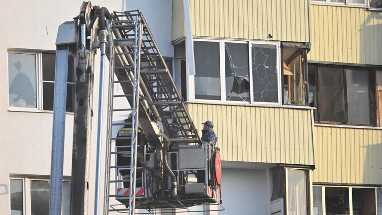 Сотрудники спецслужб у дома, поврежденного из-за падения обломков сбитого БПЛА на Домодедовской улице в Москве Сотрудники спецслужб у дома, поврежденного из-за падения обломков сбитого БПЛА на Домодедовской улице в Москве