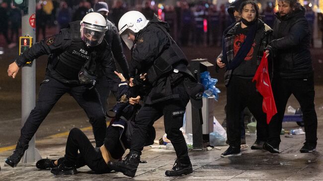 Полиция задерживает протестующих во время акции протеста в поддержку мэра Стамбула Экрема Имамоглу в Анкаре. 23 марта 2025