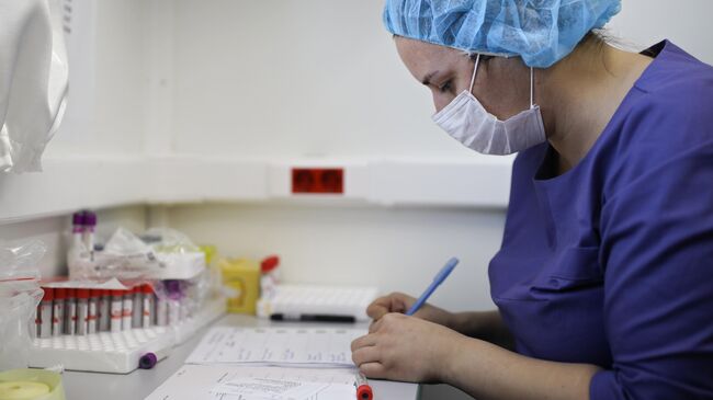 Медицинская сестра маркирует пробирки с кровью при проведении профилактического медицинского осмотра