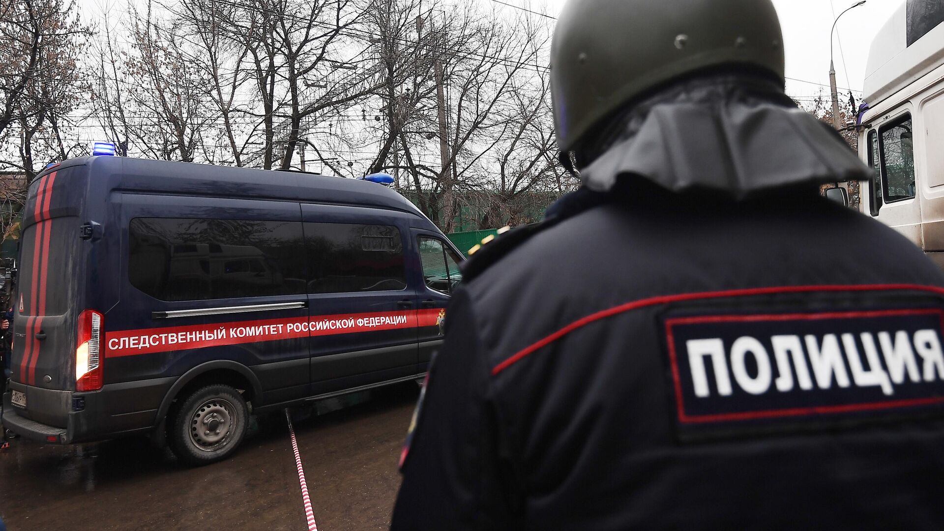 Сотрудник полиции рядом с автомобилем Следственного комитета России - РИА Новости, 1920, 24.06.2025