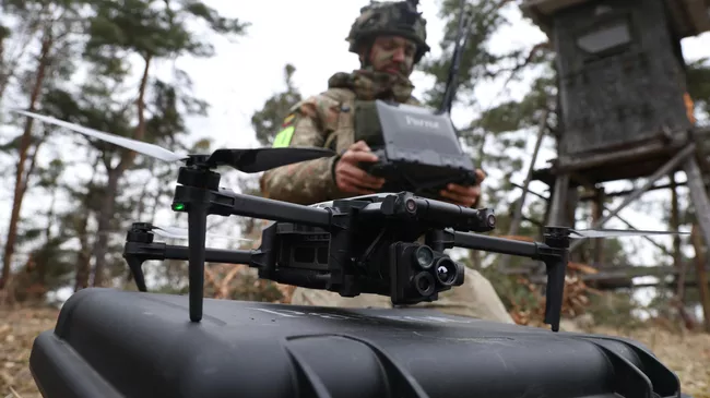 Военный готовится запустить разведывательный беспилотник Parrot во время военных учений в Германии 