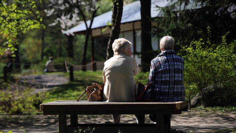 Женщины наблюдают за цветением сакуры в Главном ботаническом саду имени Н.В.Цицина Российской академии наук (РАН) в Москве