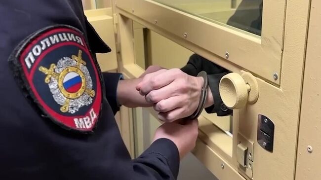 Сотрудник полиции снимает наручники