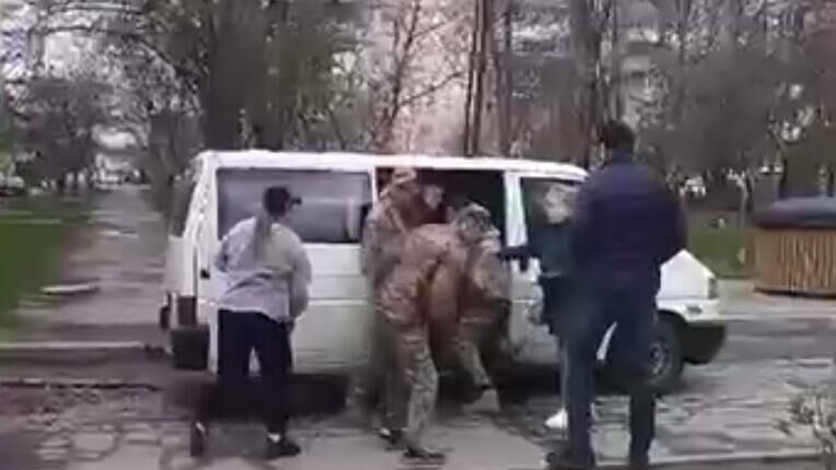 Сотрудники ТЦК в Луцке принудительно мобилизовали мужчину, провожавшего ребенка в школу. Кадр видео - РИА Новости, 1920, 23.04.2025