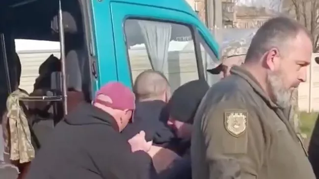 Сотрудники ТЦК Украины заталкивают мужчину в автобус