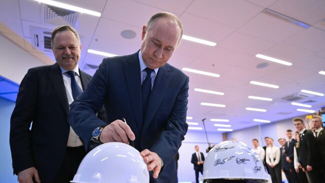 Президент России Владимир Путин оставляет на строительной каске памятную надпись во время встречи со студентами МГТУ им. Н.Э  Баумана