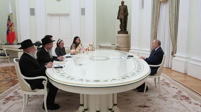 Президент РФ Владимир Путин во время встречи с бывшими заложниками ХАМАС Александром и Еленой Труфановыми и Сапир Коэн. 16 апреля 2025