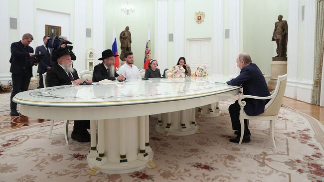 Президент РФ Владимир Путин во время встречи с бывшими заложниками ХАМАС Александром и Еленой Труфановыми и Сапир Коэн. 16 апреля 2025