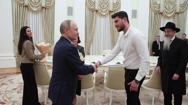Президент РФ Владимир Путин и бывший заложник ХАМАС Александр Труфанов во время встречи. 16 апреля 2025