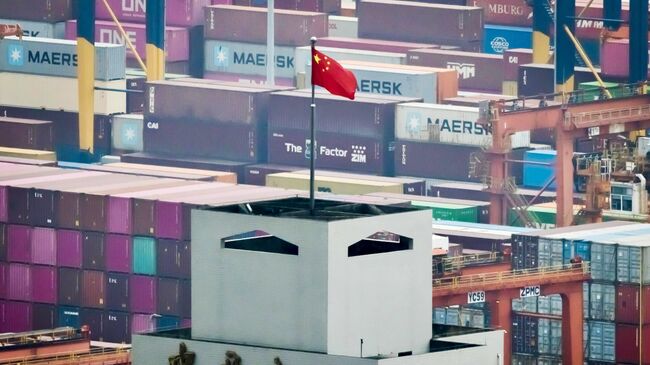 Китайский национальный флаг развевается на здании китайской таможни в международном контейнерном терминале Яньтянь