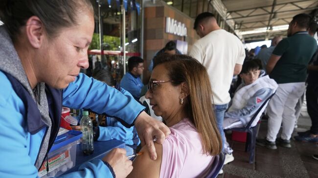 Путешественники вакцинируются от желтой лихорадки на автовокзале в Боготе, Колумбия Путешественники вакцинируются от желтой лихорадки на автовокзале в Боготе, Колумбия