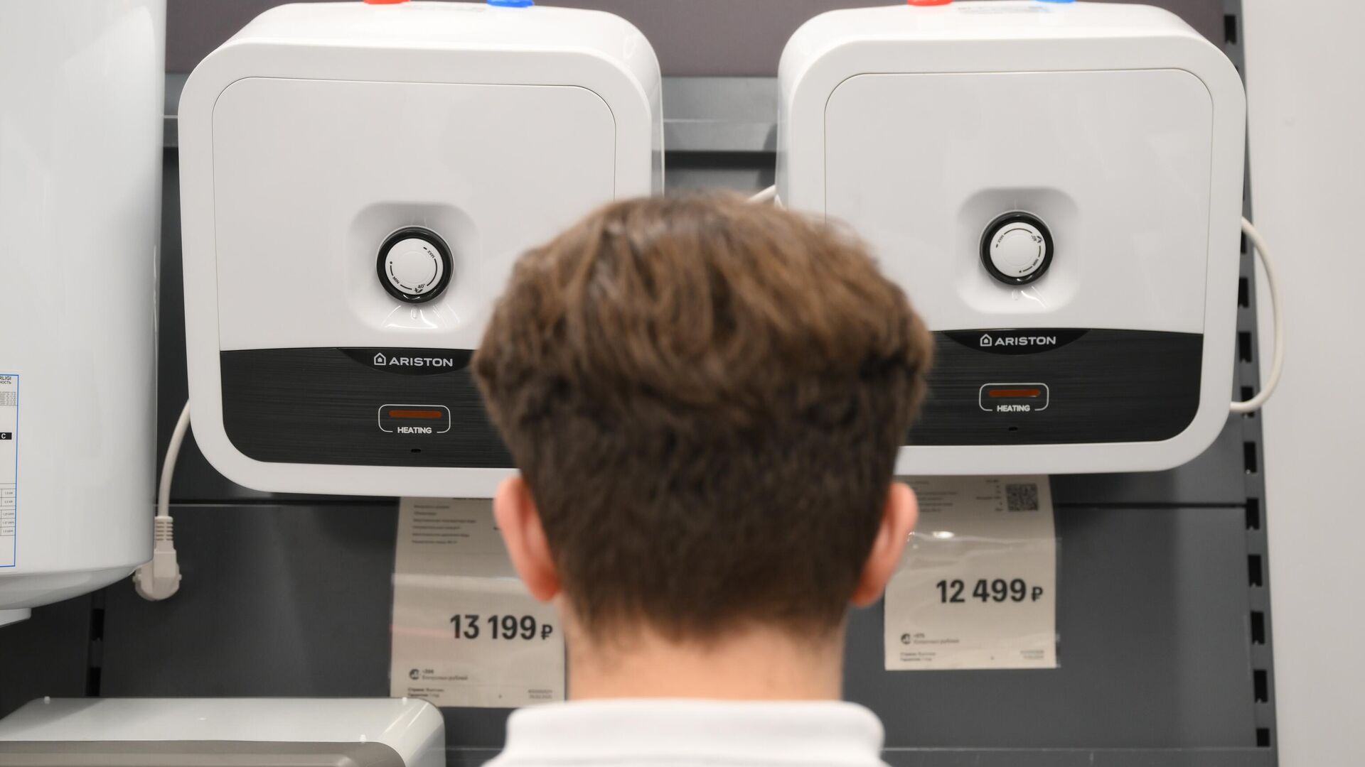 Мужчина выбирает водонагреватель зарубежного бренда Ariston в магазине М.Видео в Москв Мужчина выбирает водонагреватель зарубежного бренда Ariston в магазине М.Видео в Москв - РИА Новости, 1920, 03.05.2025