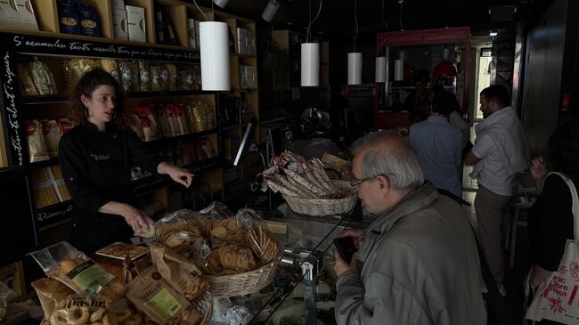 Покупатели и сотрудники продуктового магазина во время общего отключения электроэнергии в Барселоне, Испания Покупатели и сотрудники продуктового магазина во время общего отключения электроэнергии в Барселоне, Испания