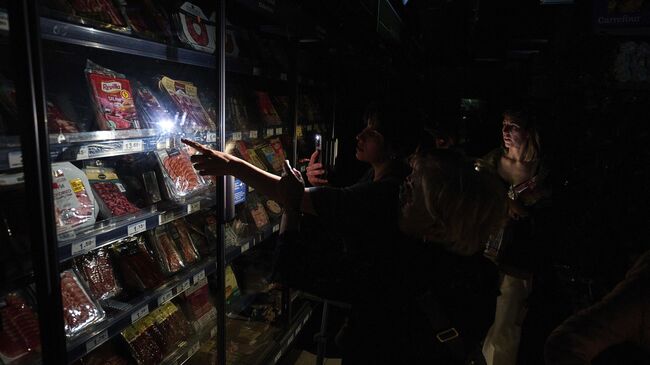 Люди в супермаркете во время массового отключения электроэнергии в Памплоне, Северная Испания