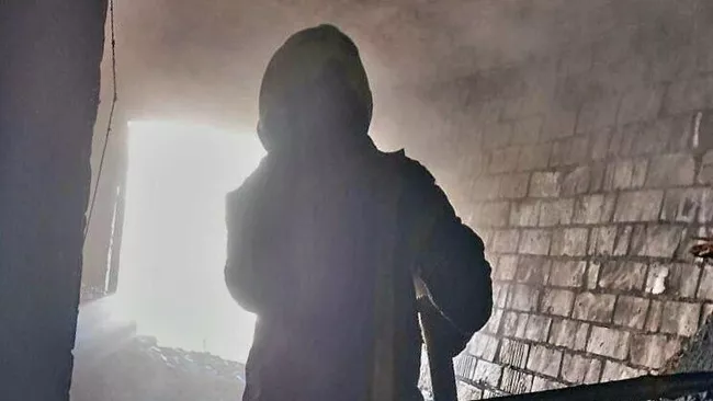 Сотрудник МЧС во время ликвидации пожара в многоэтажном доме в Великом Новгороде