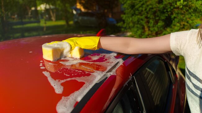 Девушка моет автомобиль