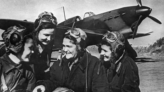 Летчицы 586-го женского истребительного авиационного полка в составе войск ПВО СССР : Галина Бурдина, Тамара Памятных, Валерия Хомякова, Валентина Лисицина у боевой машины ЯК-9 на аэродроме Анисовка под Саратовом