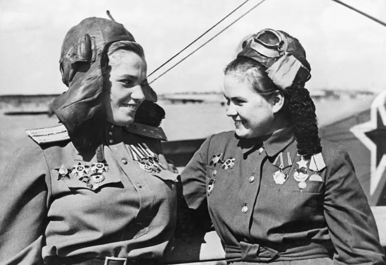 Летчицы 46-го Гвардейского ночного бомбардировочного Таманского Краснознаменного ордена Суворова авиационного полка ВВС КА Герои Советского Союза Мария Павловна Чечнева и Екатерина Васильевна Рябова у бомбардировщика По-2 Летчицы 46-го Гвардейского ночного бомбардировочного Таманского Краснознаменного ордена Суворова авиационного полка ВВС КА Герои Советского Союза Мария Павловна Чечнева и Екатерина Васильевна Рябова у бомбардировщика По-2