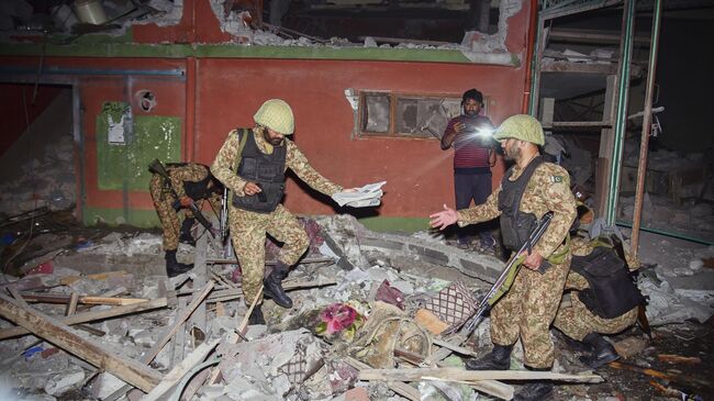 Пакистанские солдаты осматривают здание, поврежденное в результате ракетного удара со стороны Индии
