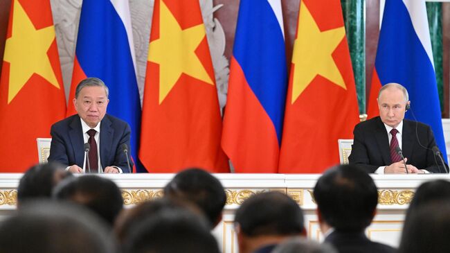 Президент России Владимир Путин и генеральный секретарь Коммунистической партии Вьетнама То Лам на церемонии подписания документов по итогам встречи