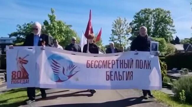 Участники акции памяти на кладбище города Генк, Бельгия. Кадр видео