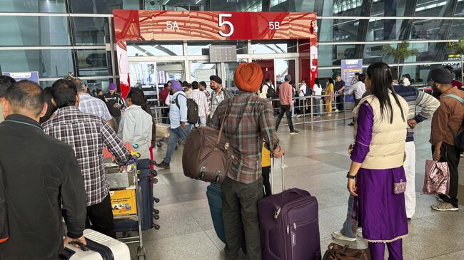 Пассажиры перед входом в здание международного аэропорта в Нью-Дели, Индия